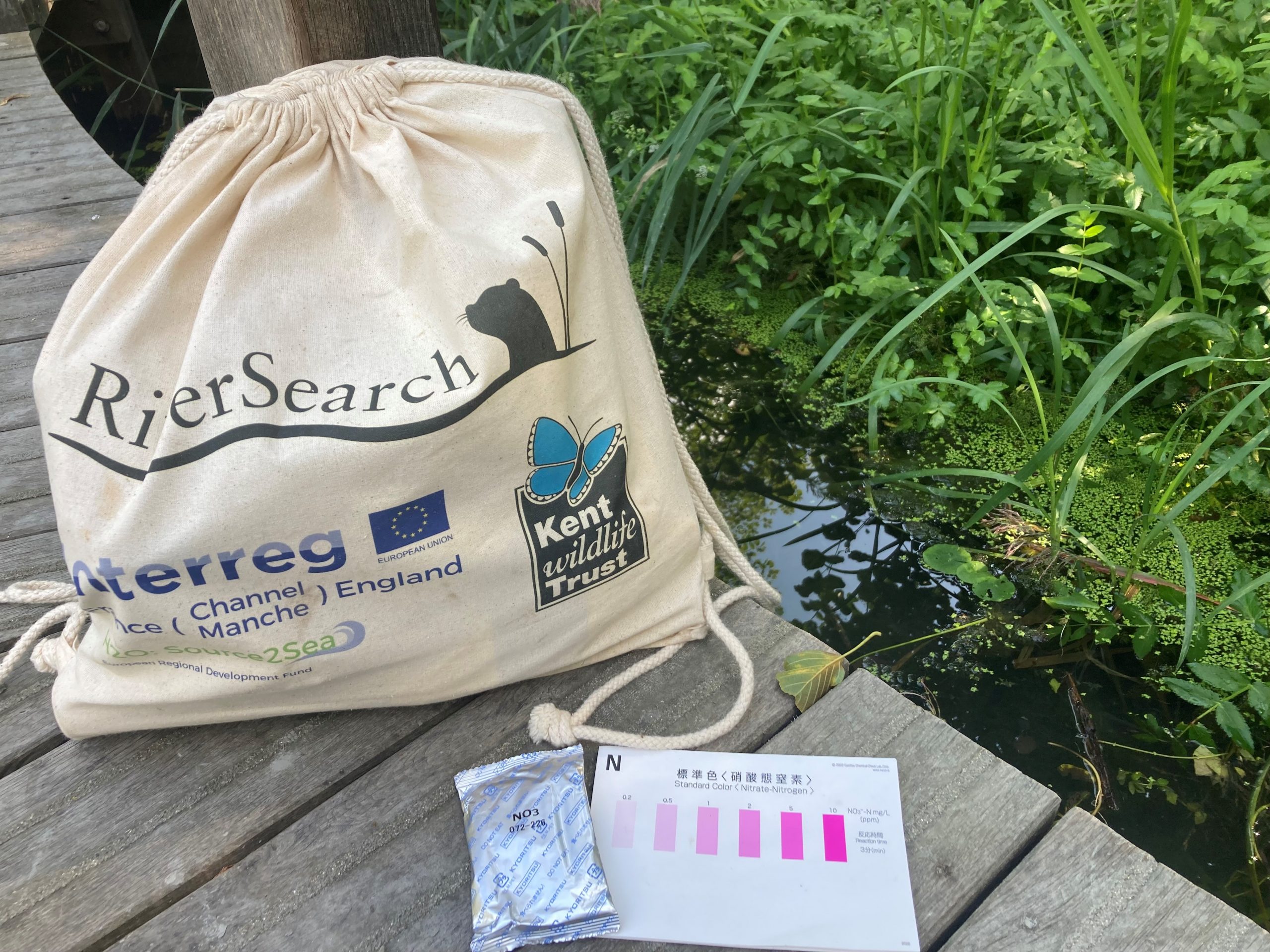 Kent Wildlife Trust River Search bag and nitrogen measurement card next to a stream.